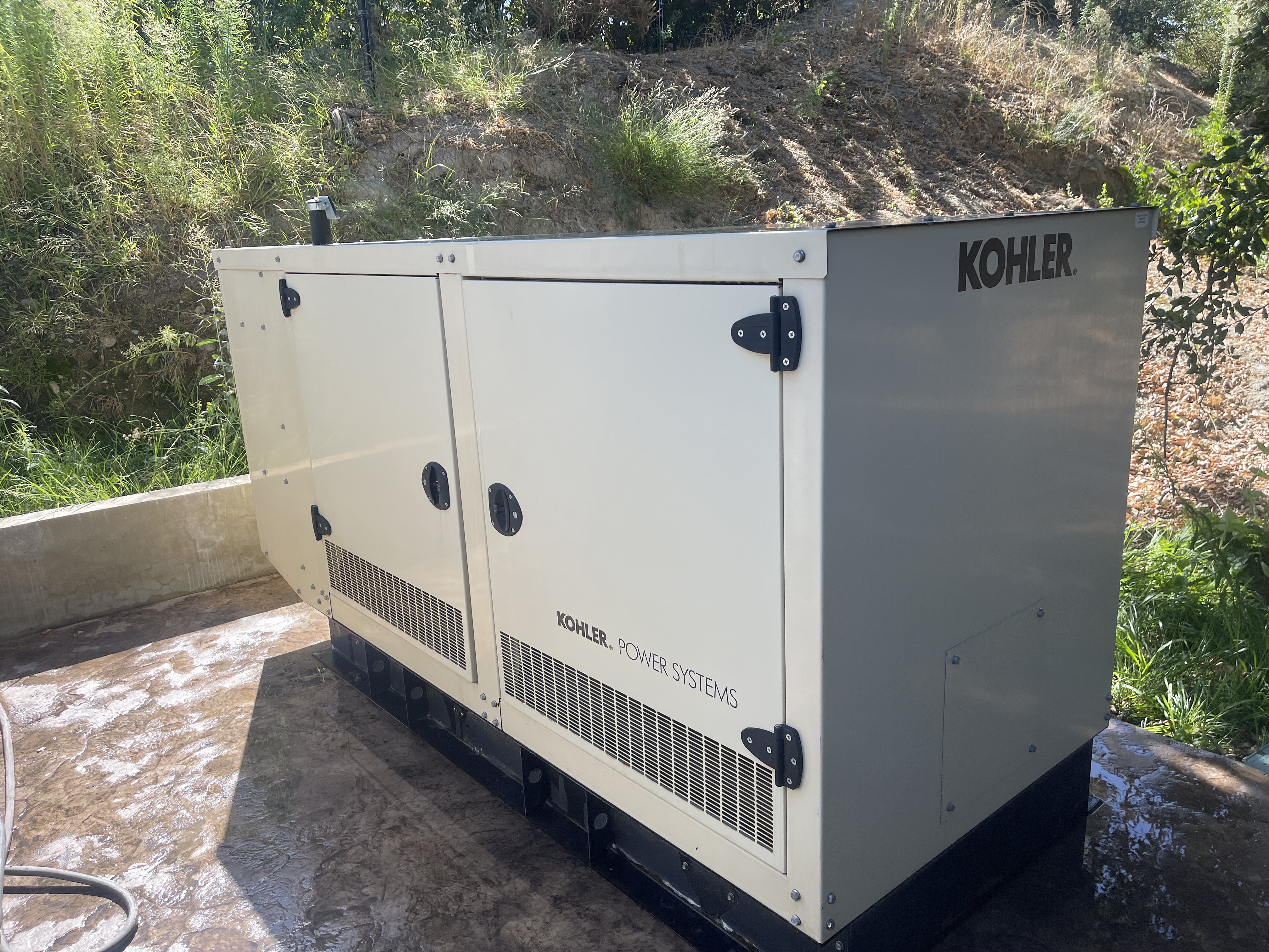 A large white generator sitting on top of a cement ground