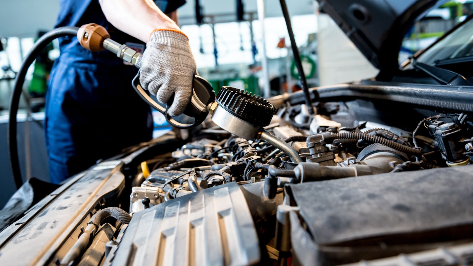 A man working on a car engine in a garage