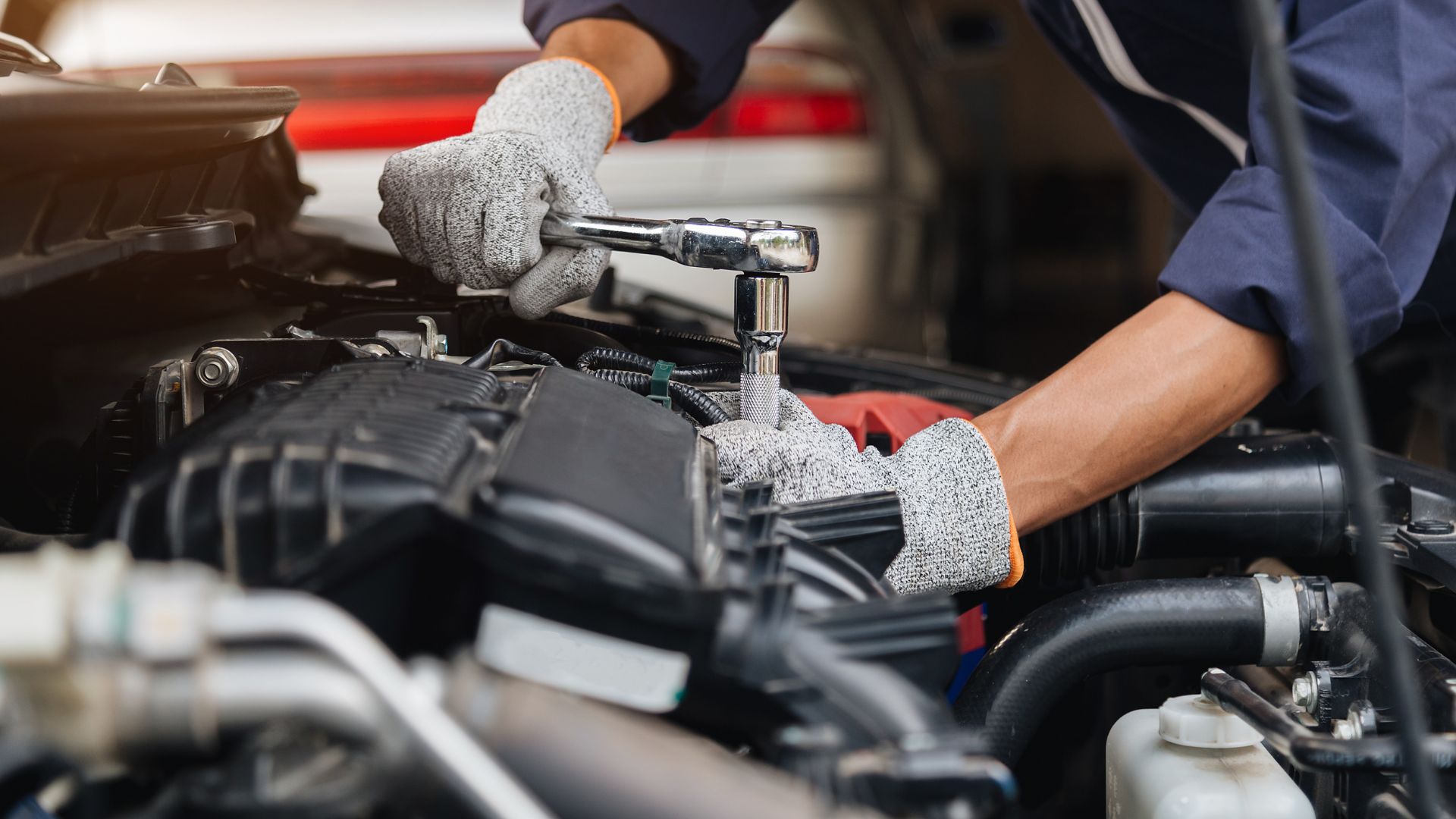 A mechanic working on a car engine